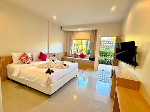 a bedroom with a bed and a flat screen tv at Transit Samui Resort in Koh Samui