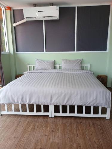 a bed in a room with a white bed frame at Spectacular Sunrise and Mountain Views in Mae Nam