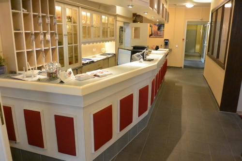 a kitchen with a counter with red and white cabinets at Hotel Deutsches Haus in Blomberg