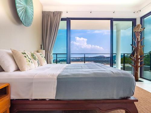 a bedroom with a bed with a view of the ocean at Tropical Sea View 2Br Private Pool Villa in Plai Laem