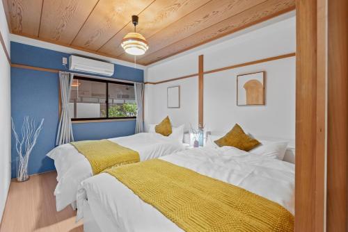 two beds in a room with blue and white at Crystal Jade Awaza2-4F in Wada