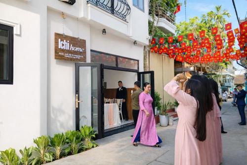 a group of women taking pictures of a store on a street at ICHI Home Kim Long in Hue