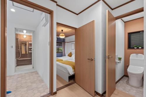 a bathroom with a bed and a toilet in a room at Crystal Jade Awaza2-4F in Wada