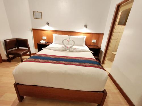 a hotel room with a bed with a bow on it at Saphi Inn Cusco - Excelente ubicación in Cusco