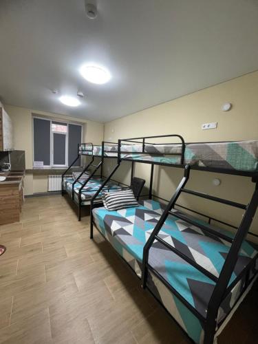 a room with three bunk beds in a room at Apart Rooms & Hostel 5 Capsule Rooms in Ustʼ-Kamenogorsk