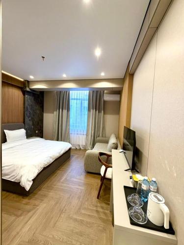 ein Schlafzimmer mit einem Bett und einem Schreibtisch mit Computer in der Unterkunft Hotel Elora in Almaty