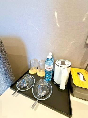 ein Tablett mit Gläsern und einer Flasche Wasser darauf in der Unterkunft Hotel Elora in Almaty