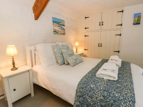 a bedroom with a bed with towels on it at Fern Cottage in Cardigan