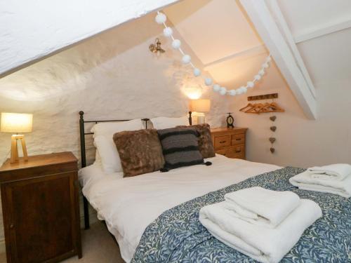 a bedroom with a bed with towels on it at Rose Cottage in Cardigan