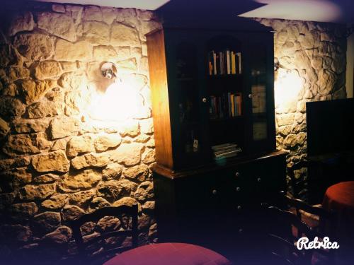 a room with a stone wall with a lamp and a cabinet at Il Peschio in Pescocostanzo