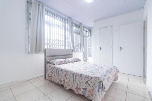a bedroom with a bed and a large window at Guest House Central in Florianópolis