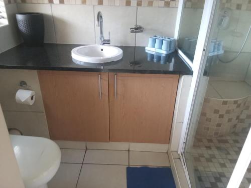 a bathroom with a sink and a toilet and a shower at Cabanas Del Mar 31 in Kingsborough