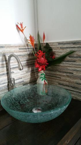 a bathroom sink with a vase with flowers in it at Carmen's place in Bastimentos