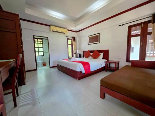 a bedroom with a large bed and a room with at First Bungalow Beach Resort in Chaweng