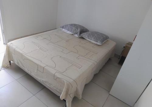 a bed in a room with two pillows on it at Abricotier à proximité des plages du sud in Rivière-Pilote