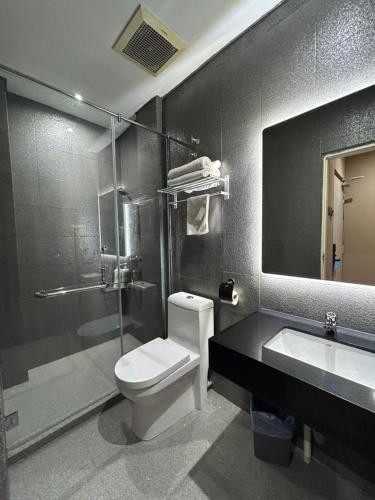 a bathroom with a toilet and a sink and a shower at Hotel Ming Star in Kuala Terengganu