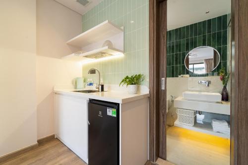 a small kitchen with a sink and a mirror at Nina Sky Serviced Apartment in Ho Chi Minh City
