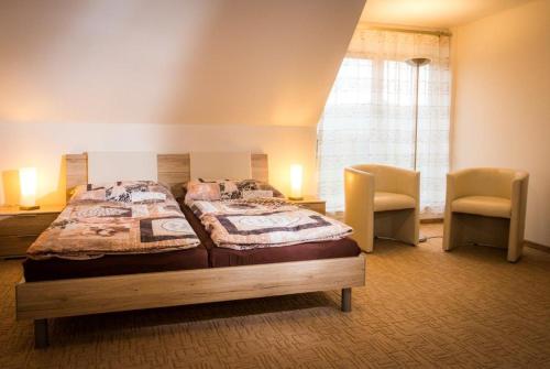 sypialnia z dużym łóżkiem i 2 krzesłami w obiekcie Golf Resort Česká Lípa w mieście Nový Bor