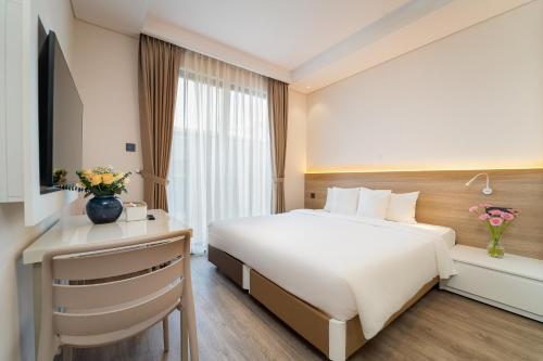 a hotel room with a bed and a desk at Nina Sky Serviced Apartment in Ho Chi Minh City