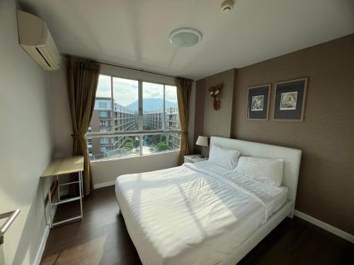 a bedroom with a white bed and a large window at Dcondo Creek Phuket 2BR in Kathu