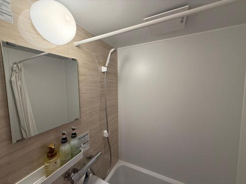 a bathroom with a mirror and a sink at Private house 海Kai in Nagato
