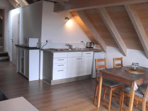 eine Küche mit einem Holztisch sowie einem Tisch und Stühlen in der Unterkunft Ferienwohnung Elisabeth in Riedenburg
