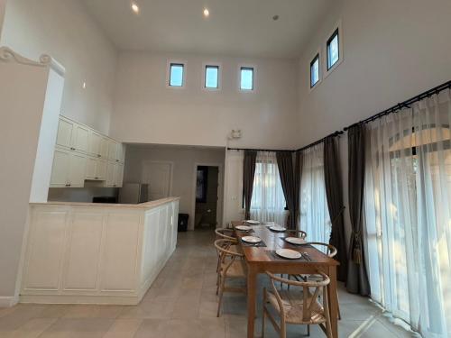 a kitchen with a table and chairs in a room at Estella Pool Villas Pattaya Formerly Chivani Pattaya in Na Jomtien