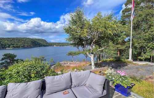 a couch sitting next to a body of water at Nice Home In Risør With House Sea View in Risør