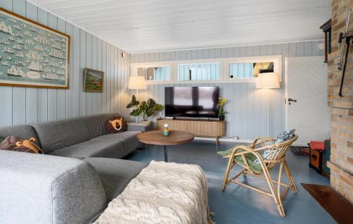 a living room with a couch and a tv at Nice Home In Risør With House Sea View in Risør
