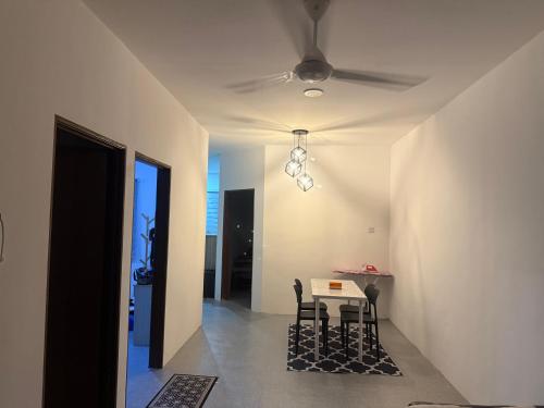 a dining room with a table and chairs and a ceiling at DF Homestay in Kangar