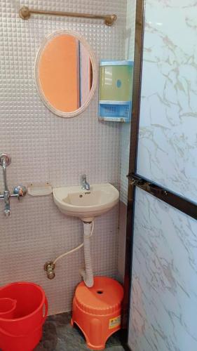 a small bathroom with a sink and a red stool at Sky cottage in Jāmb