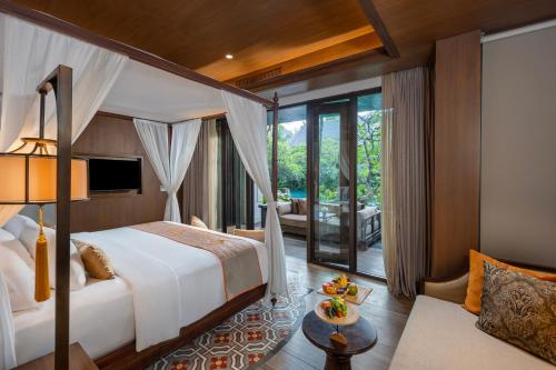 a bedroom with a bed and a living room at Ramayana Suites and Resort in Kuta