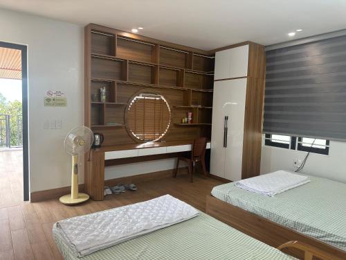 a room with two beds and a desk with a fan at Bong Mai Thai Hoa Hotel in Làng Dương