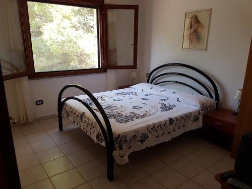 1 dormitorio con 1 cama en una habitación con ventana en Casa Giovanna, en Porto Pino