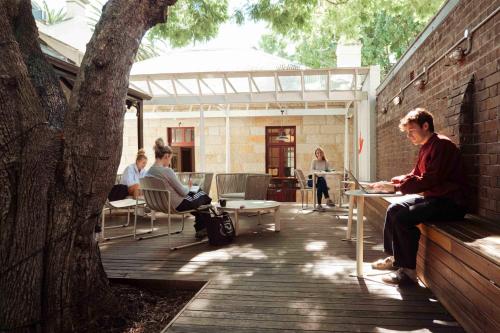 a man sitting at a table on a patio at Little Drifter Surry Hills in Sydney