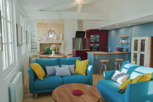 sala de estar con sofá azul y mesa en La Loge du 12, en Burdeos