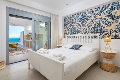 a bedroom with a bed with a view of the ocean at Villa Aristoteles in Lindos