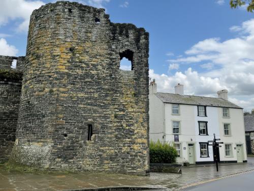an old stone tower in front of a building at Millgate Cottage in Conwy