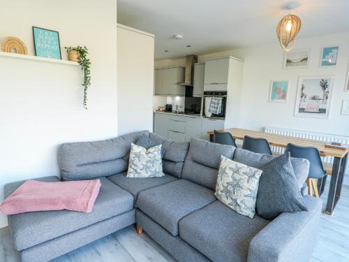 a living room with a couch and a kitchen at Dune Retreat in Rhosneigr