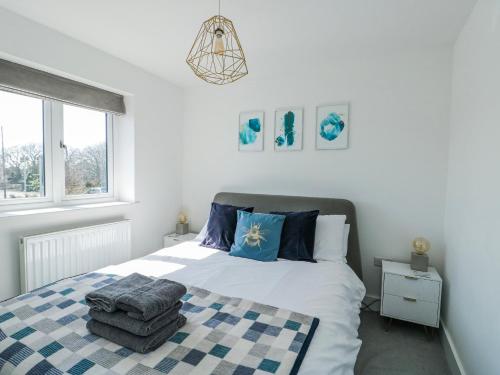 a bedroom with a bed and a window at Dune Retreat in Rhosneigr