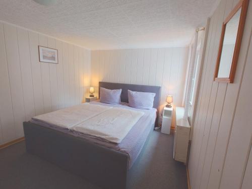 a bedroom with a bed with white sheets and pillows at Haus Katharina in Loissin