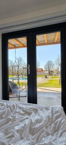 a bedroom with a bed and a view of a playground at Badash Tiny Village - Tiny Houses with Heated Pool & BBQ in Polovragi