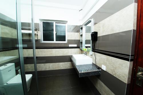 a bathroom with a sink and a mirror at Hotel Emerald Green in Weligama