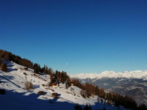 a snow covered mountain with houses on the side of it at Sunny chalet in Veysonnaz for 10 guests in Veysonnaz