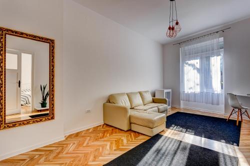 - un salon avec un canapé et un miroir dans l'établissement Bright Apartment Central, à Belgrade