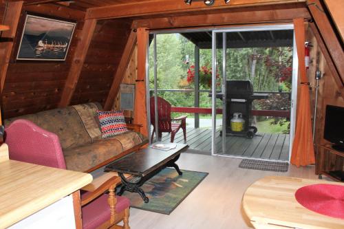 a living room with a couch and a screened in porch at Sunny Bluffs Chalets in Kaslo