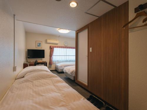 a hotel room with two beds and a television at Hotel Union in Kagoshima