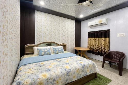 a bedroom with a bed and a chair at HOTEL SHIVAYY MAJESTIC - BHU Sundarpur Road 3km from KASHI VISHWANATH TEMPLE in Varanasi