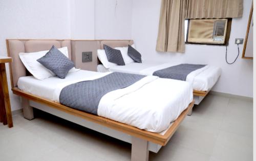zwei Betten in einem Hotelzimmer mit in der Unterkunft Hotel Excellency in Dīsa