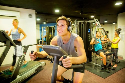 a man riding a treadmill in a gym at Space Hotel in Melbourne